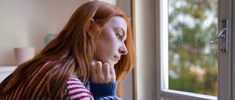 Young woman indoors on a rainy day